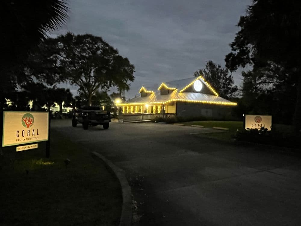 Coral Family Cemetery illuminated at night with festive lights and surrounding trees.