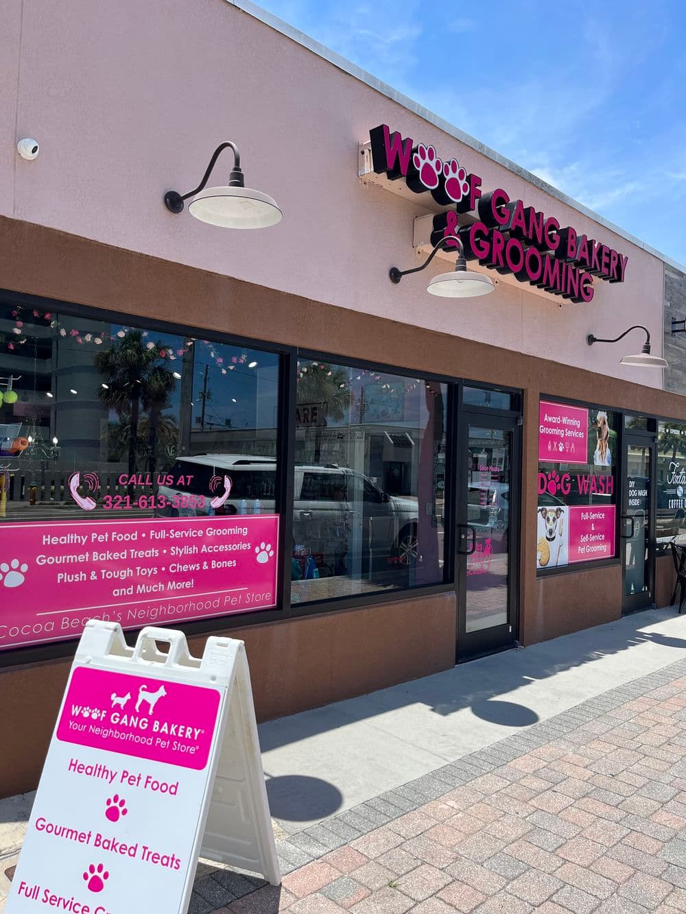 Exterior of Woof Gang Bakery & Grooming featuring pet food and grooming services sign.