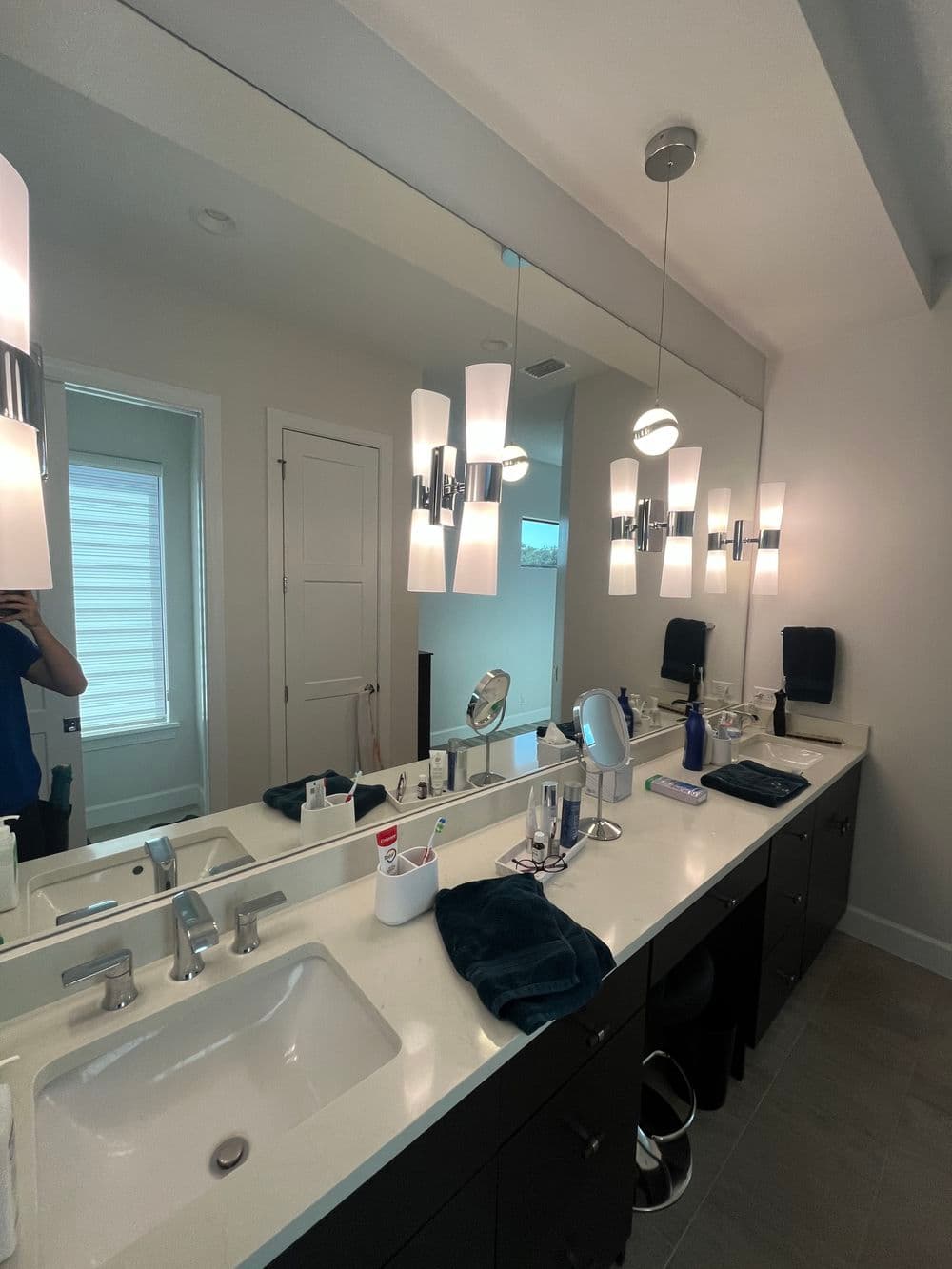 Modern bathroom with stylish lighting, double sinks, and sleek cabinetry. Bright and spacious design.