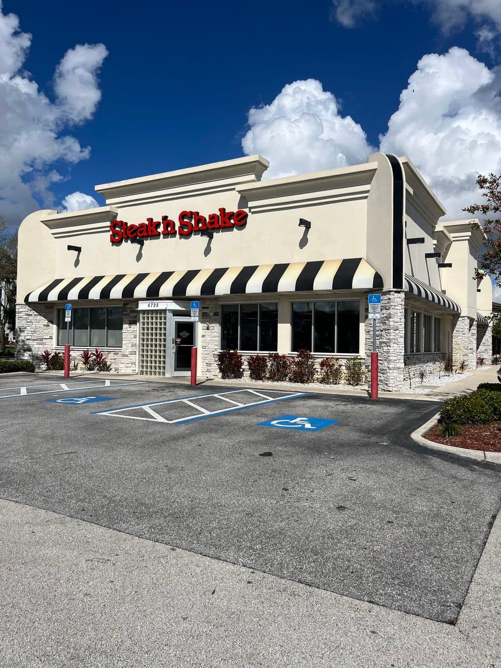 Steak 'n Shake restaurant exterior with stripes and clear blue sky in the background.
