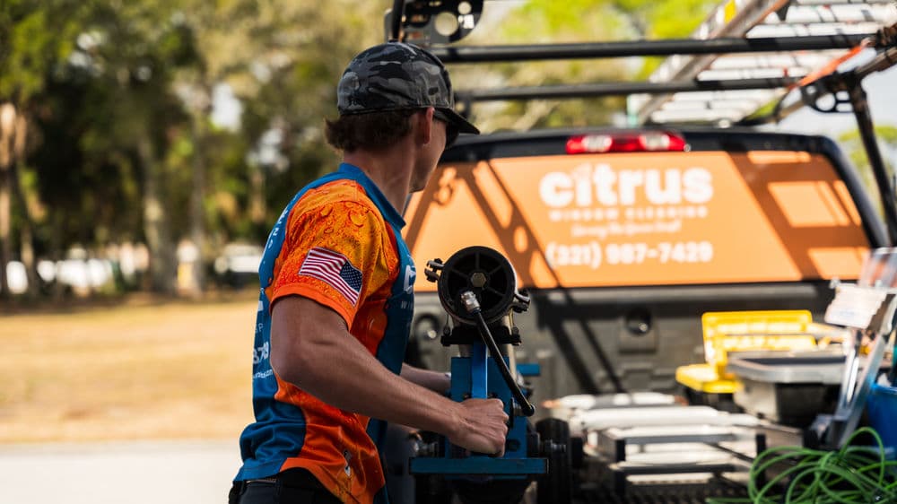 Technician loading equipment into a truck marked with "Citrus" for fieldwork.